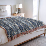 Sansevieria Leaf Cotton Throw Blanket in Blue, on a bed