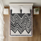 Addai Abstract Triangle Pattern Blanket Throw in Gray, on a bed