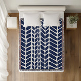 Freda Hand Woven Throw Blanket in Navy Blue, on a bed