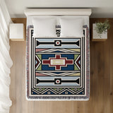 Ndebele Tribal Cotton Throw Blanket in Blue, Green and Red, on a bed