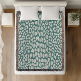 Delo Animal Print Cotton Blend Blanket Throw in Teal, on a bed
