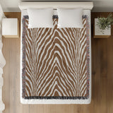 Zoe Animal Print Cotton Blend Blanket Throw in Rust Brown, on a bed