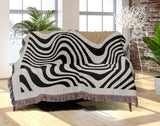 Acor Abstract Cotton Blend Blanket Throw in Beige and Off-White, draped over a chair