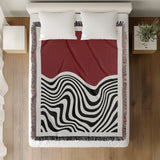 Acor Abstract Cotton Blend Blanket Throw in Red and Off-White, on a bed