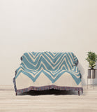 Addai Abstract Triangle Pattern Blanket Throw in Blue and Beige, draped over a sofa