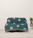Akon Hand Woven Throw Blanket in Teal and Beige, draped over a sofa