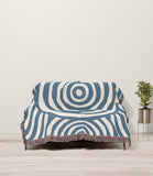 Alaka Circles Cotton Throw Blanket in Blue and Beige, draped over a sofa