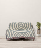 Alaka Circles Cotton Throw Blanket in Gray and Beige, draped over a sofa
