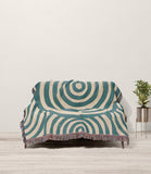 Alaka Circles Cotton Throw Blanket in Teal and Beige, draped over a sofa