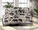 Alfie Elephant Cotton Blend Blanket Throw in Brown and Off-White, draped over a chair