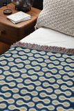 Alo Cotton Blend Blanket Throw in Blue, on a bed