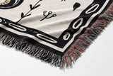 Amiro Crocodile Cotton Blend Blanket Throw in Black and Off-White, draped over a chair