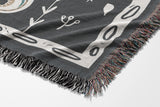 Amiro Crocodile Cotton Blend Blanket Throw in Gray and Off-White, draped over a chair