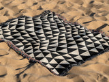 Asaba Abstract Cotton Throw Blanket in Black and Beige, outdoors