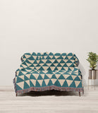 Asaba Abstract Cotton Throw Blanket in Teal and Beige, draped over a sofa