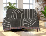Askii Cotton Blend Blanket Throw in Gray, draped over a chair