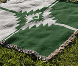 Asko Southwestern Cotton Blend Blanket Throw in Green and Off-White, draped over a chair