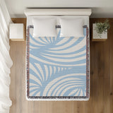 Konga Hand Woven Throw Blanket in Sky Blue, on a bed