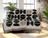 Barro Abstract Cotton Blend Blanket Throw in Beige, Black and Off-White, draped over a chair