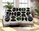 Barro Abstract Cotton Blend Blanket Throw in Green, Black and Off-White, draped over a chair