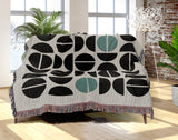 Barro Abstract Cotton Blend Blanket Throw in Teal, Black and Off-White, draped over a chair