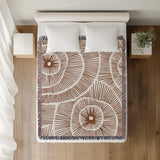Ray Abstract Print Cotton Throw Blanket in Rust Brown, on a bed