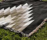 Bimisii Southwestern Cotton Blend Blanket Throw in Beige, Black and Off-White, draped over a chair