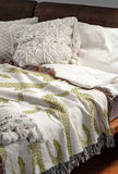 Bolt Leopard Cotton Blend Blanket Throw in Chartreuse and Off-White, draped over a chair