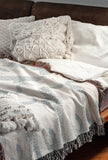 Bolt Leopard Cotton Blend Blanket Throw in Light Gray and Off-White, draped over a chair