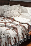 Bolt Leopard Cotton Blend Blanket Throw in Rust Brown and Off-White, draped over a chair