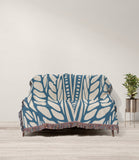 Buga Abstract Print Cotton Throw Blanket in Blue and Beige, draped over a sofa