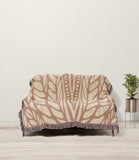 Buga Abstract Print Cotton Throw Blanket in Rust and Beige, draped over a sofa