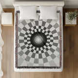 Bullseye Abstract Cotton Blend Blanket Throw in Gray and Off-White, on a bed