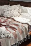 Bullseye Abstract Cotton Blend Blanket Throw in Red and Off-White, draped over a chair