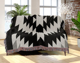 Caca Southwestern Cotton Blend Blanket Throw in Black and Off-White, draped over a chair