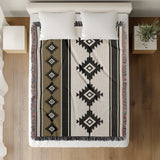 Carlos Southwestern Cotton Blend Blanket Throw in Black, Off-White and Dull Gold, on a bed