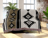 Carlos Southwestern Cotton Blend Blanket Throw in Black, Off-White and Dull Gold, draped over a chair