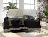 Carney Elephant Cotton Blend Blanket Throw in Black, Gray and Gold, draped over a chair