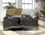 Carney Elephant Cotton Blend Blanket Throw in Gray and Gold, draped over a chair