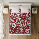 Addy Floral Cotton Throw Blanket in Red, on a bed