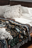 Cece Elephant Cotton Blend Blanket Throw in Black, Blue and Beige, on a bed