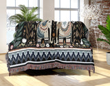 Cece Elephant Cotton Blend Blanket Throw in Black, Blue and Beige, draped over a chair