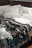 Cece Elephant Cotton Blend Blanket Throw in Black, Green and Yellow, on a bed