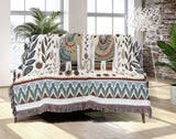 Cece Elephant Cotton Blend Blanket Throw in Beige, Blue and Off-White, draped over a chair