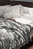 Chitto Southwestern Cotton Blend Blanket Throw in Gray and Off-White, draped over a chair