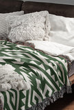 Chitto Southwestern Cotton Blend Blanket Throw in Green and Off-White, draped over a chair