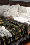 Cube Cotton Blend Blanket Throw in Black, on a bed
