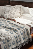 Cube Cotton Blend Blanket Throw in Blue, on a bed