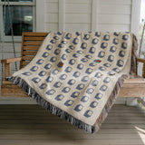 Cube Cotton Blend Blanket Throw in Blue, draped over a chair