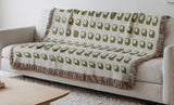 Cube Cotton Blend Blanket Throw in Chartreuse, draped over a chair